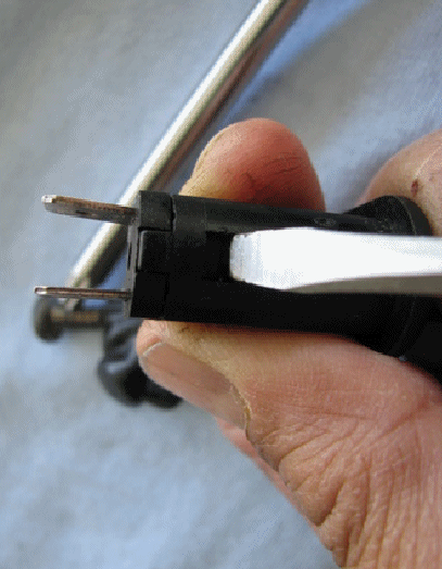 Insert fine tip flat screw driver as shown and press in and up gently, there are two sides to release catch.
