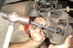 Using a Punch to Tap Pins Securely Into the Caliper