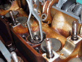 Depressing the valve spring.